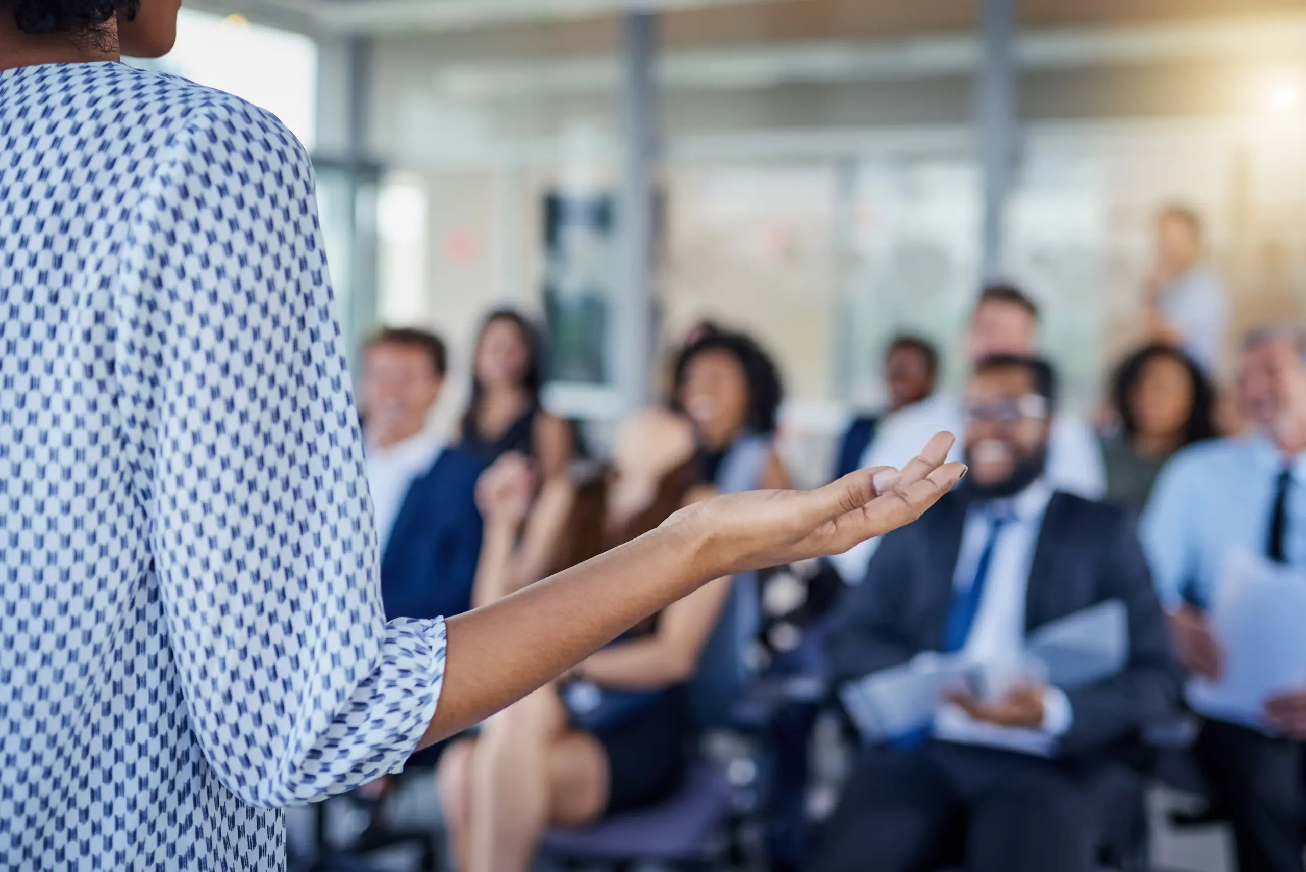 Presentation, a hand, and a woman as a speaker at a conference for training or a workshop. Business, corporate, and a female manager speaking to a crowd at a seminar or convention for leadership or mentoring.